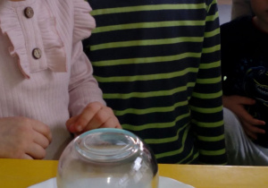 Dzieci dostrzegają gasnącą świeczkę i wodę wessaną do środka szklanki